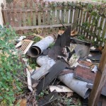 Debris on ground from repairing chimney and roof-picket fence with ivy